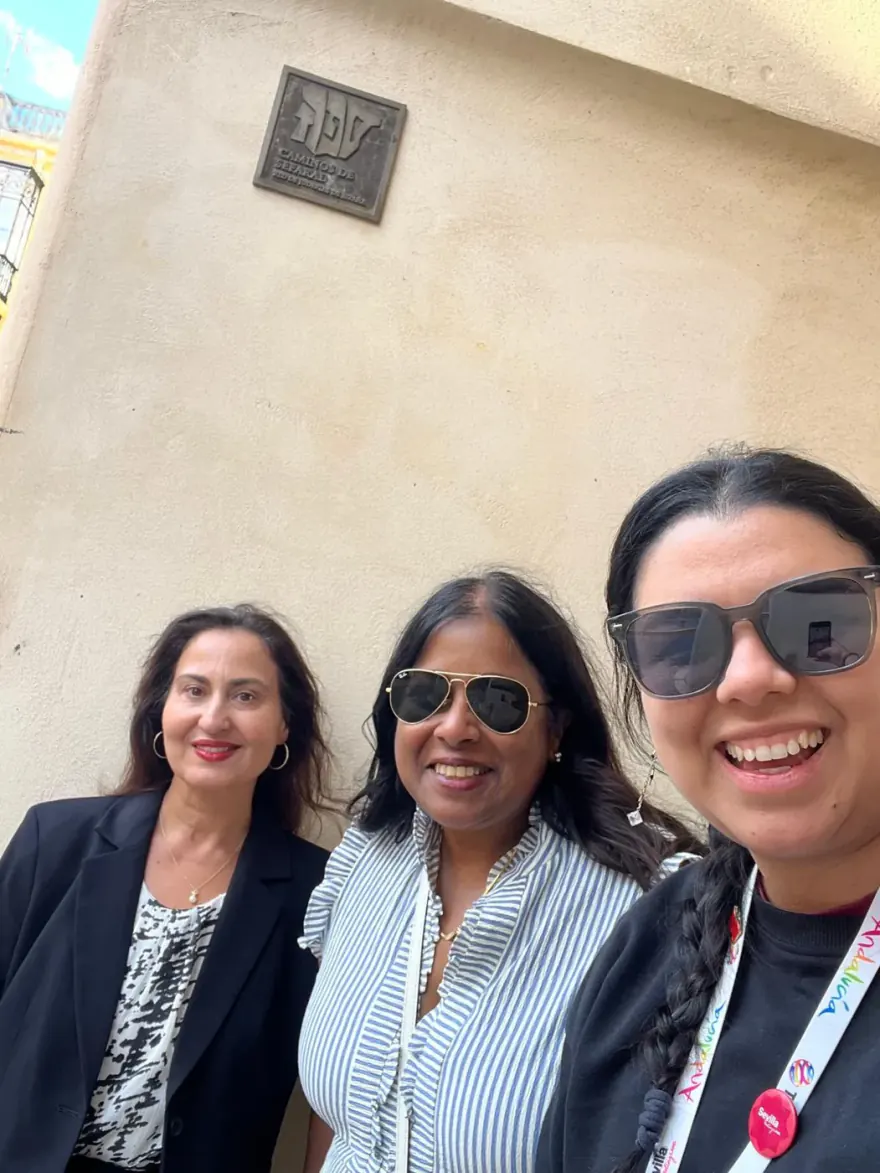 Three visitors under the plaque of the Network of Jewish Quarters of Spain — Caminos de Sefarad